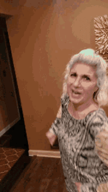 a woman with gray hair is standing in a room