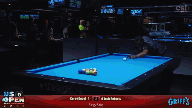 a pool table sponsored by griff 's shows a game between corey deuel and josh roberts