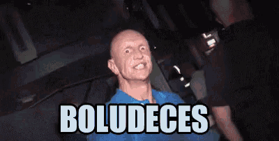 a bald man in a blue shirt is sitting in a chair with the words " boludeces " on the bottom