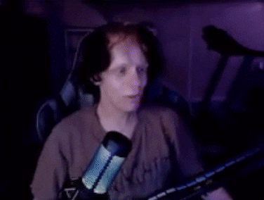 a man with red hair is sitting in front of a microphone .