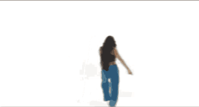 a woman wearing a black crop top and blue pants