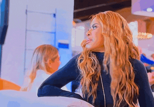 a woman with long blonde hair wearing a black turtleneck