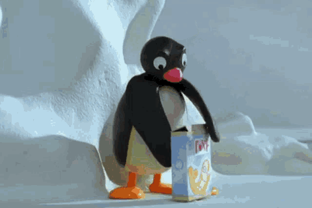 a cartoon penguin is standing next to a box of ice cream .