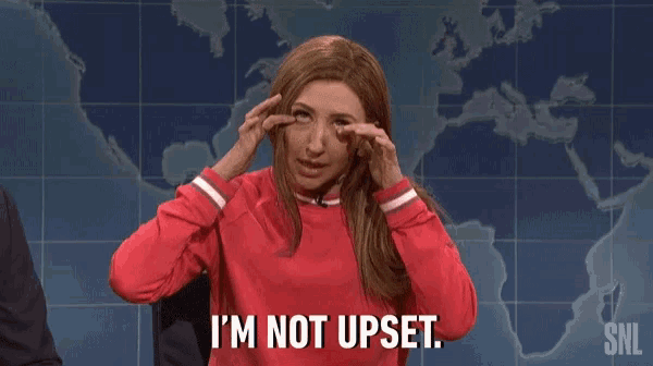 a woman in a red sweater is making a funny face and says `` i 'm not upset '' .