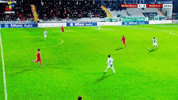 a group of soccer players on a field with a banner for allianz auto behind them