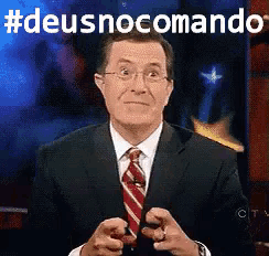 a man in a suit and tie says #deusnocomando on a screen