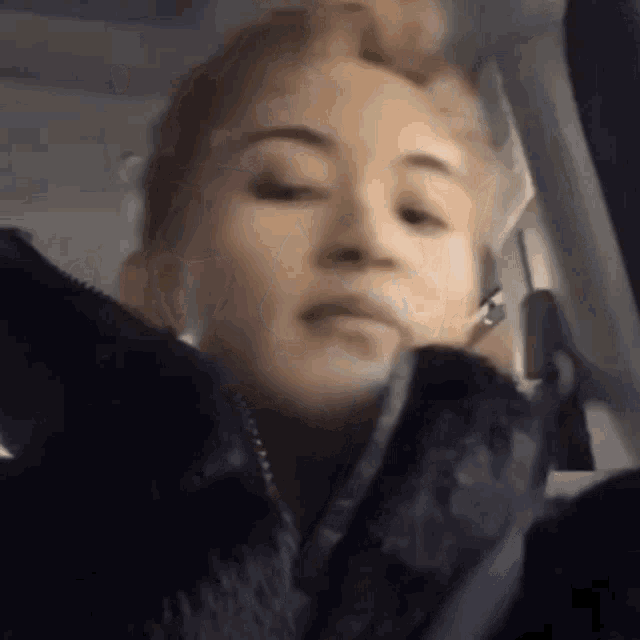 a close up of a woman 's face while talking on a cell phone