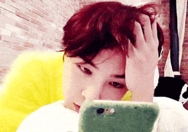 a man with red hair is looking at a cell phone