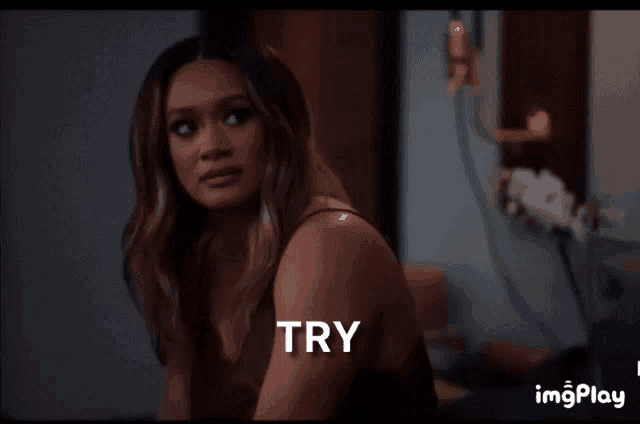 a woman is sitting in a room with the word try written on her shoulder