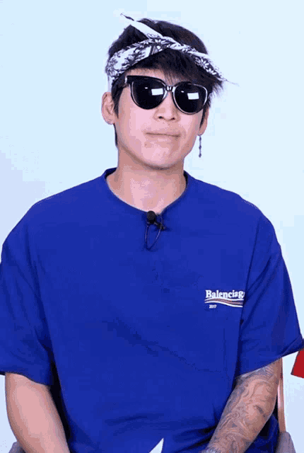 a man wearing sunglasses and a blue balenciaga t-shirt