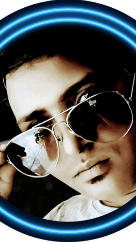 a man wearing sunglasses looks at the camera with a blue glow around him