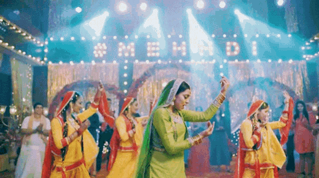 a group of people are dancing in front of a sign that says mehrdi