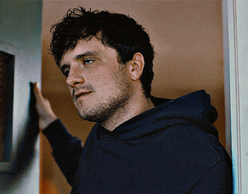 a man leaning against a wall with his hand on it