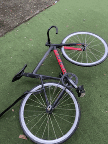 a bicycle is laying on the grass with the front wheel missing