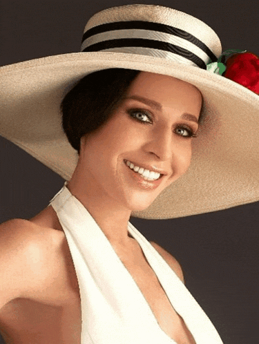 a woman wearing a straw hat with a red rose on it