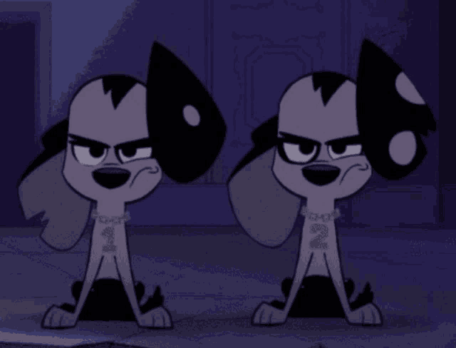 two dalmatian dogs are sitting next to each other and one has the number 2 on its chest
