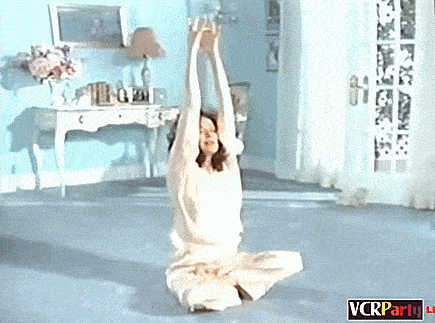 a woman is stretching her arms in a room with a vcrparty logo on the bottom right