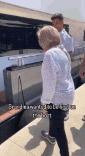 a woman standing next to a boat with the words grandma wanted to be first on the boat