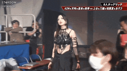 a woman in a black top is standing in front of a sign that says stardom