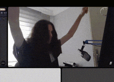 a woman dancing in front of a microphone with the word inda on the bottom left