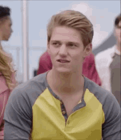 a young man wearing a yellow and gray shirt