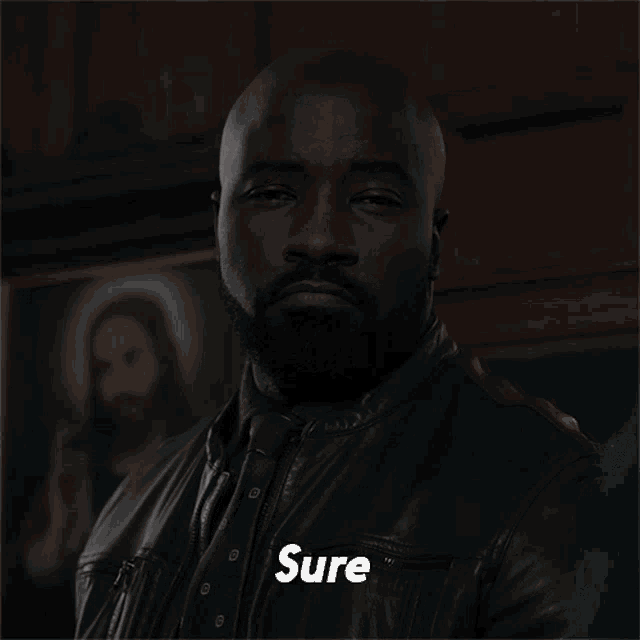 a man in a leather jacket has the word sure on his chest