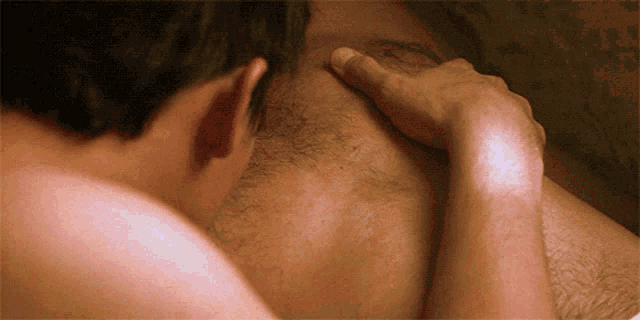 a man with a beard is being touched by another man 's hand