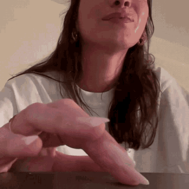 a close up of a woman 's face with a white t-shirt on