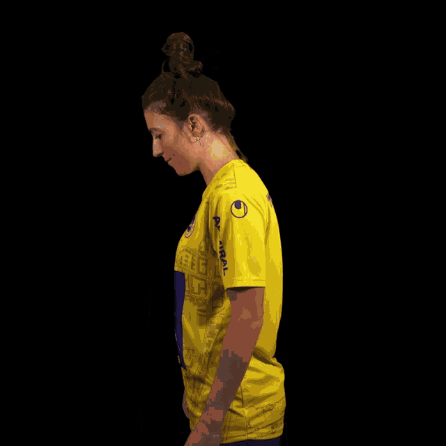 a woman wearing a yellow shirt with immo and uniqa on it