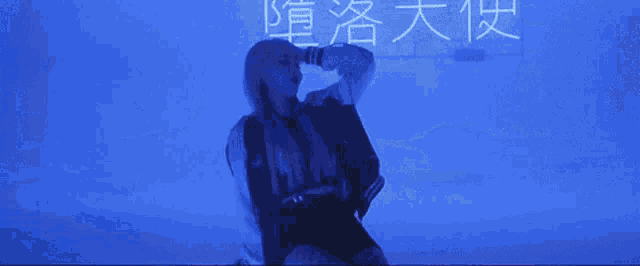a woman stands in front of a blue background with chinese characters