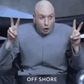 a bald man is sitting in a chair giving a peace sign .