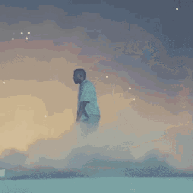 a man is standing on top of a stage with smoke coming out of it .