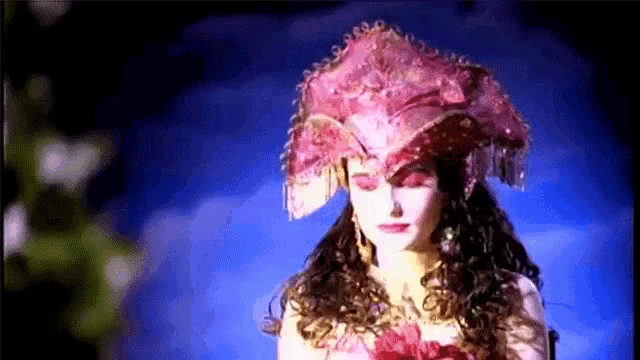 a woman is wearing a pink hat with fringe on it