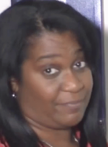 a close up of a woman 's face with black hair and earrings .