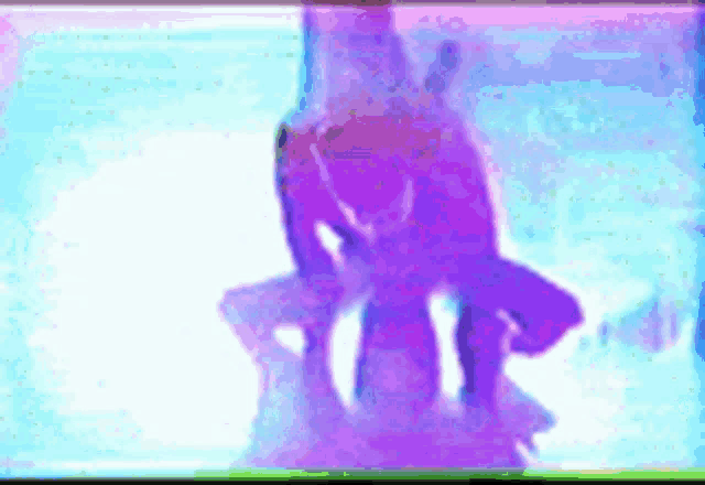 a blurry picture of a man in a purple suit standing in a pool of water .