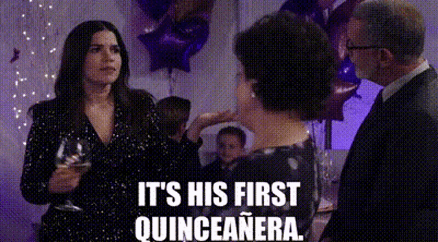 a woman is holding a glass of wine while standing next to a man at a party .