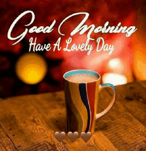 a cup of coffee is on a wooden table with the words `` good morning have a lovely day '' .