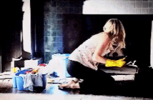 a woman wearing yellow gloves is kneeling on the floor