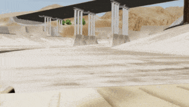 a military vehicle is driving under a bridge in a desert