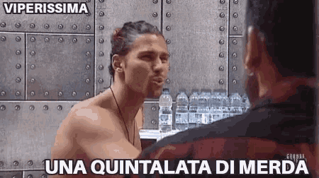 a shirtless man talking to another shirtless man with the words una quintalata di merda