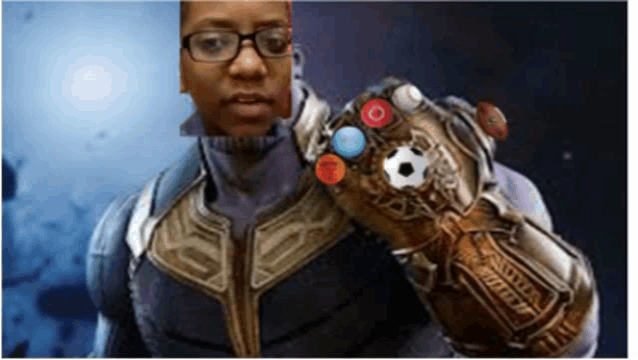 a man in a superhero costume is holding a glove that has a soccer ball on it