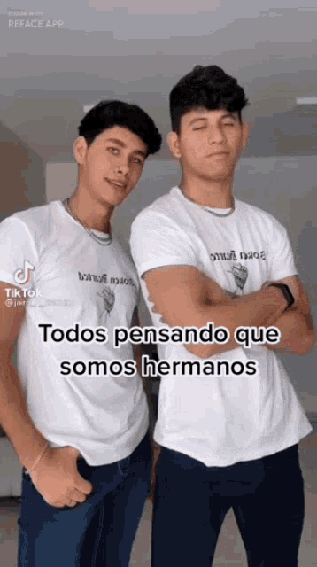 two men wearing white shirts that say todos pensando que somos hermanos are standing next to each other