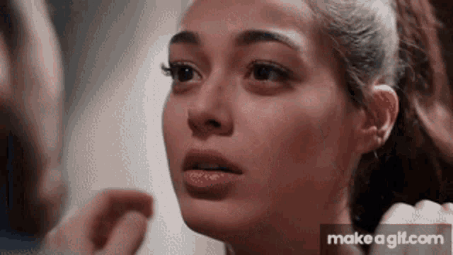 a close up of a woman 's face with make a gif.com in the bottom right corner