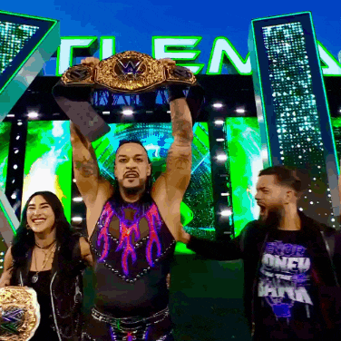 a man is holding up a wrestling championship belt in front of a sign that says clean