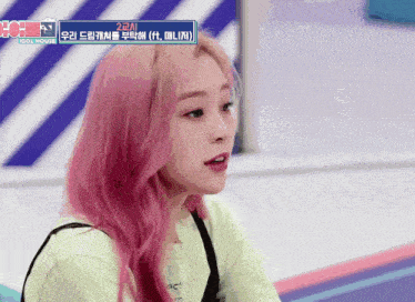 a girl with pink hair is wearing a green shirt that says act