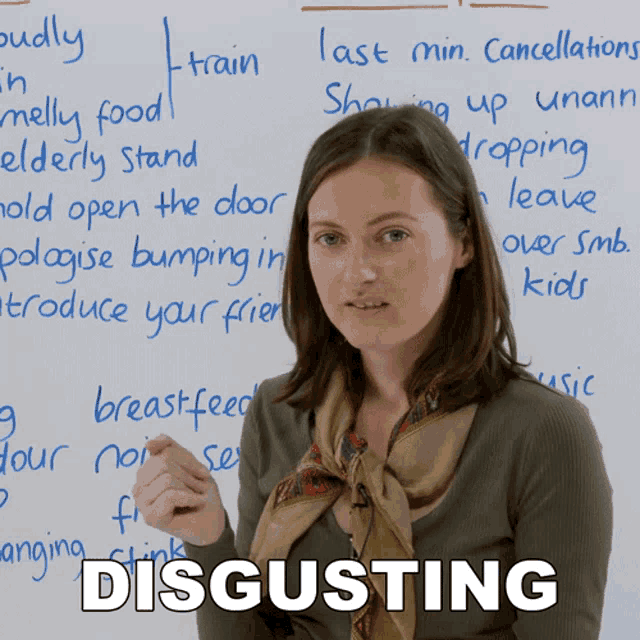 a woman is standing in front of a whiteboard with the word disgusting written on it
