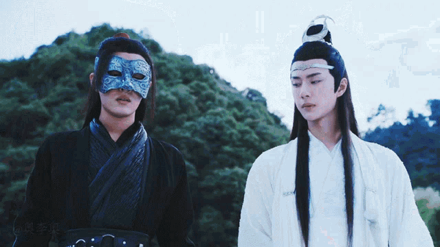 a man wearing a mask stands next to another man in a white robe