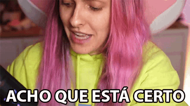 a woman with pink hair is wearing a neon green hoodie and says acho que esta certo