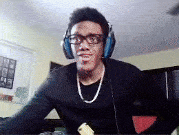 a man wearing headphones and glasses is sitting at a desk