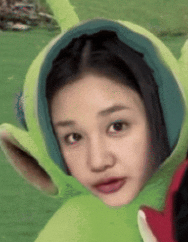 a woman is wearing a green hat that looks like a teletubbies character